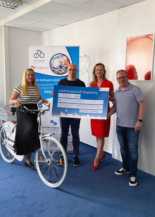 Scheckübergabe aus dem Ottostadt-Verfügungsfond durch die Wirtschaftsbeigeordnete Sandra Yvonne Stieger an die in4MD Service GmbH für ihre Otto Bikes Model Company zur SAP-Ausbildung